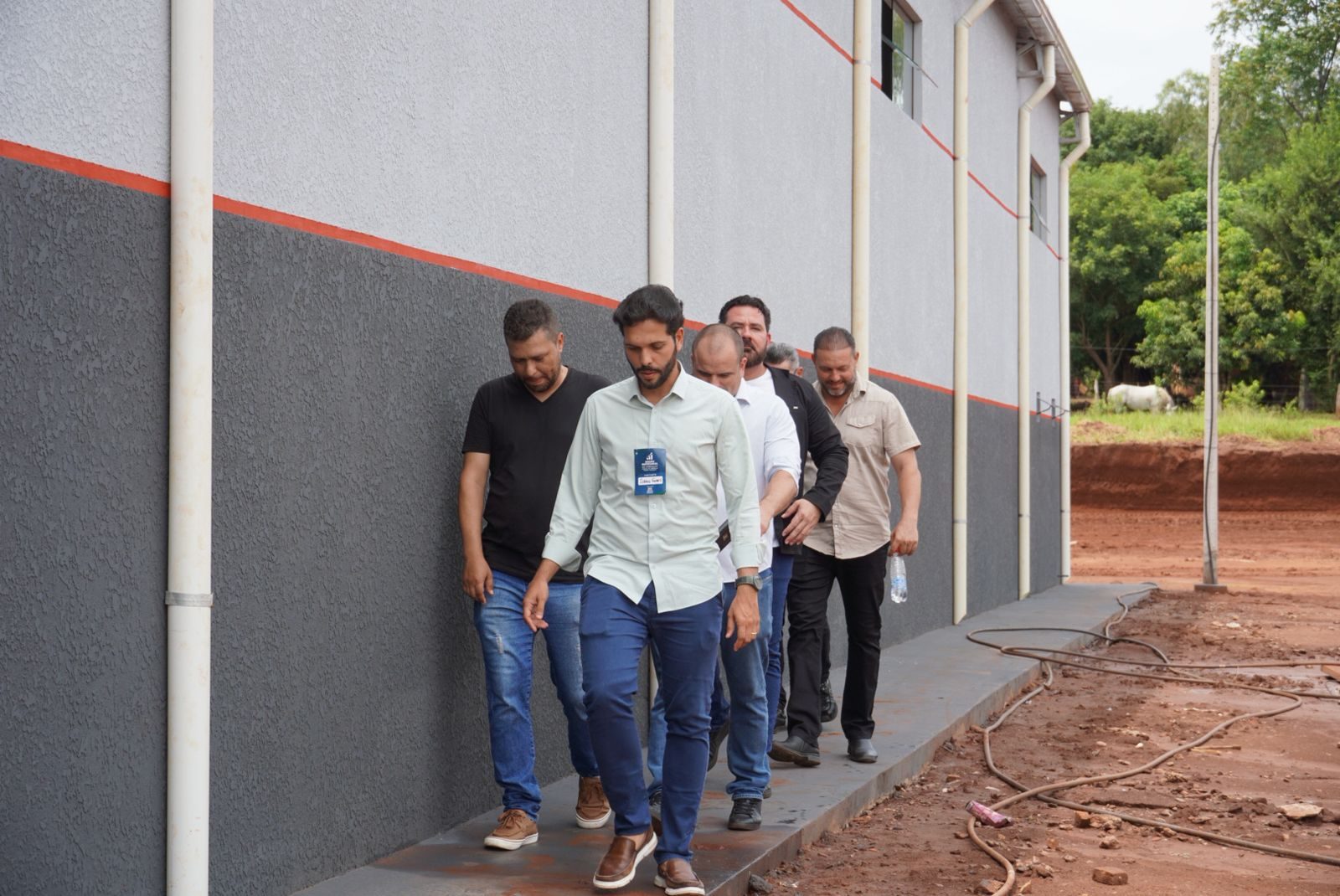 Comitiva percorrendo galpão industrial em construção